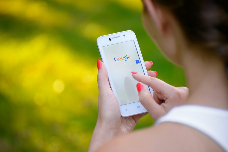 young woman using google web search on her smart phone