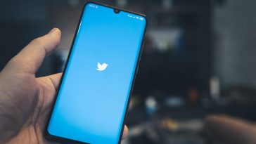 twitter on the screen of a black smartphone in a mans hand